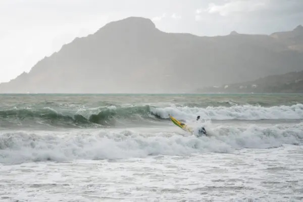 Seekajak-Fahrer fährt durch Wellen auf's Meer